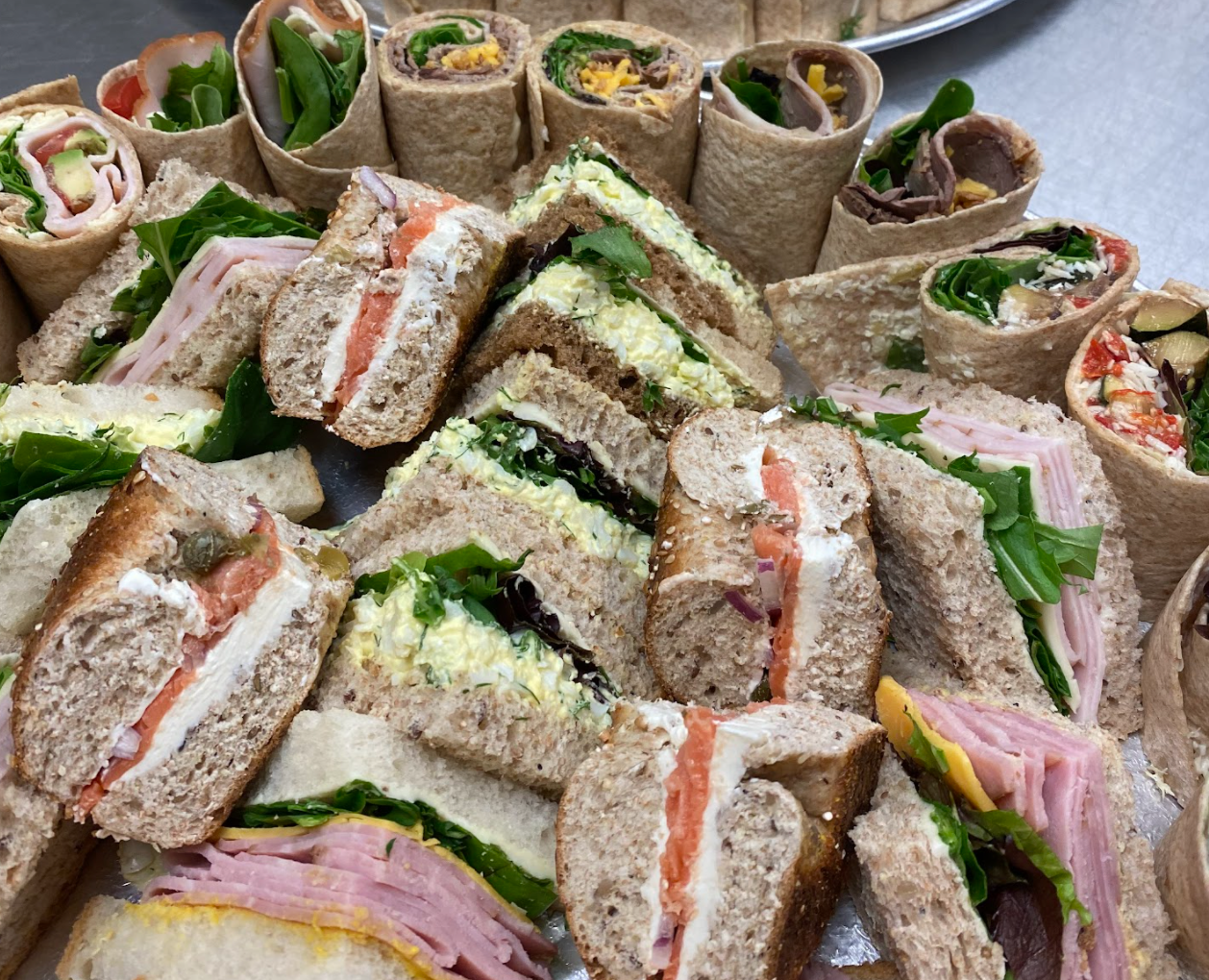 MeMe's Cafe catering featuring our famous sandwich platter, including cream cheese and salmon bagels, vegetarian wraps, and ham and cheddar sandwiches.
